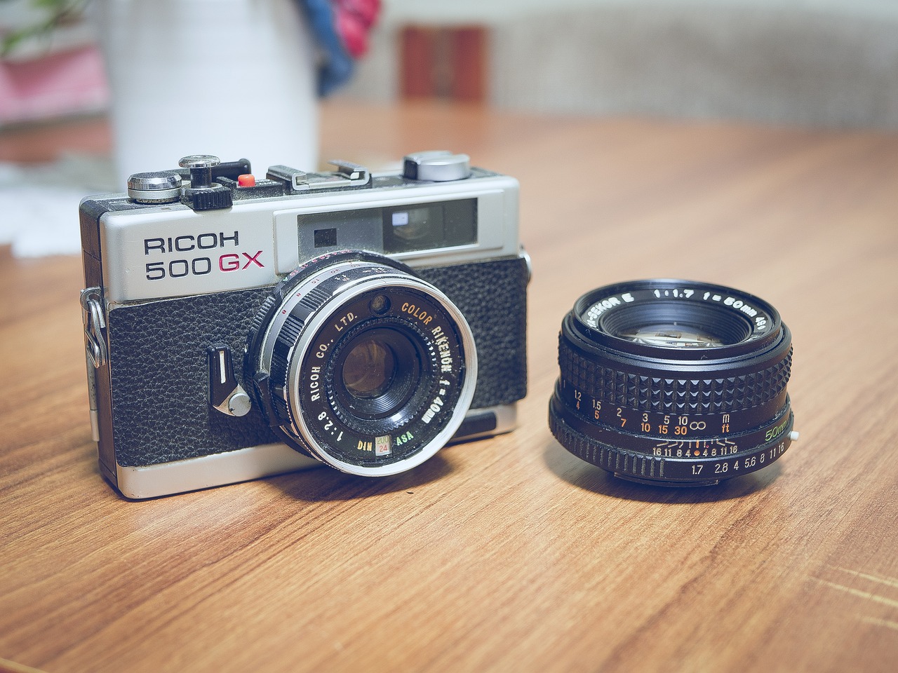 A black and silver camera sitting on a wooden table