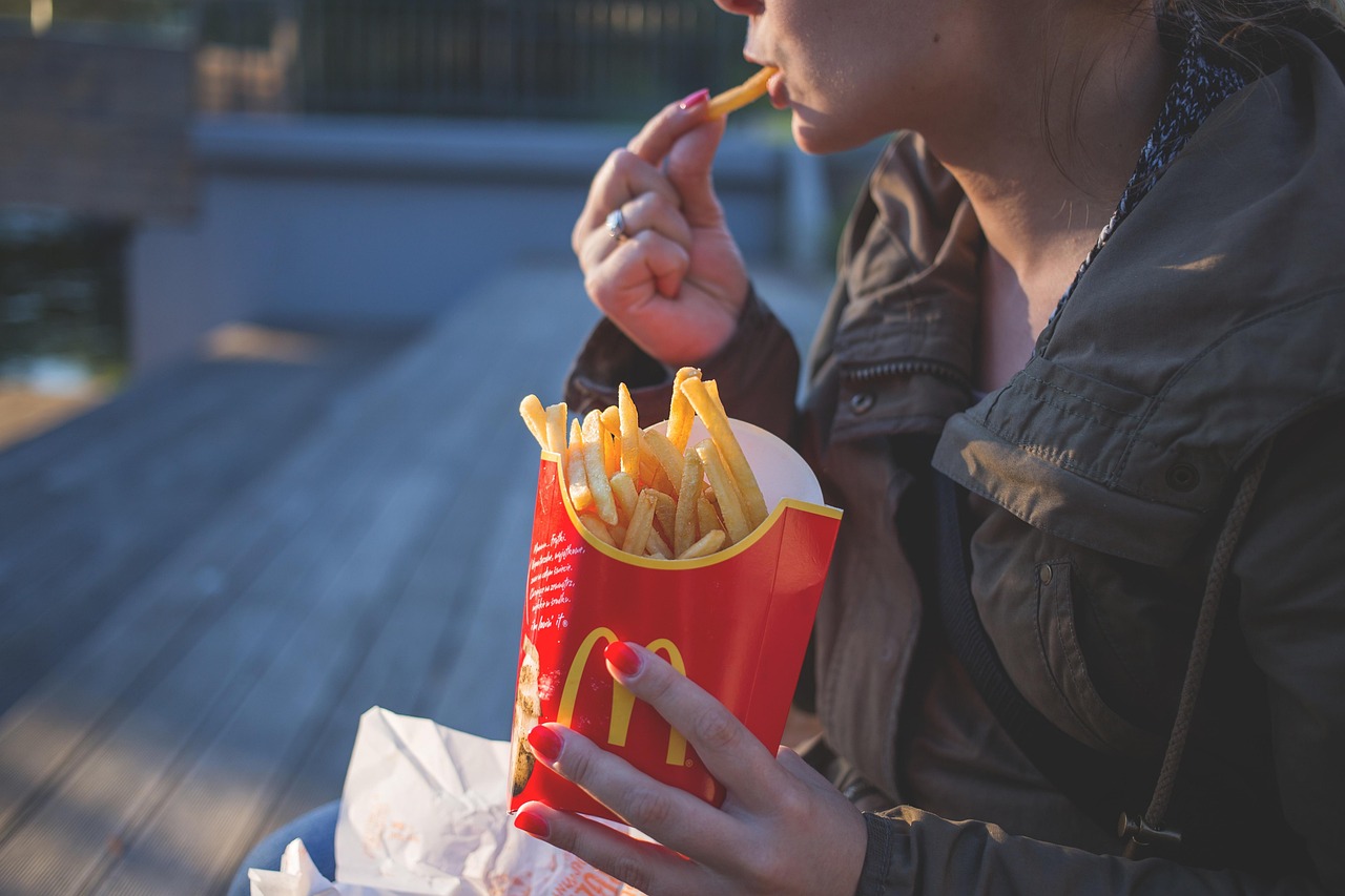 someone eating french fries from a fast food restaurant