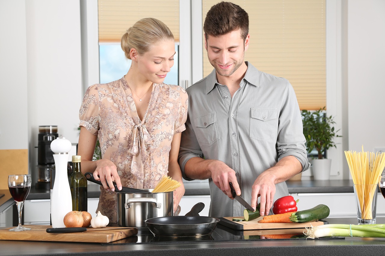 One person cooking with the other person watching