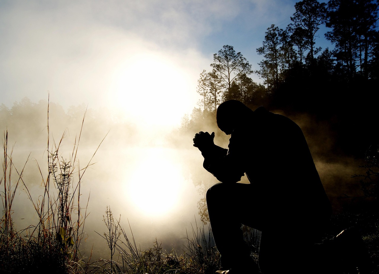 person praying outside with lots of fog